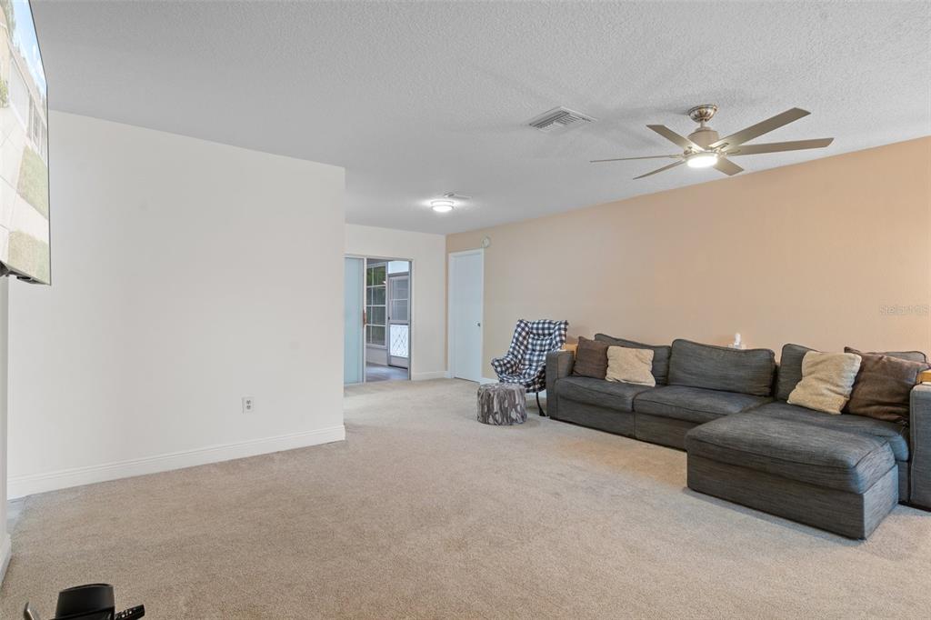 8130 Merrimac Drive Port Richey, FL 34668 - Photo 7 of 53 a living room with furniture and a ceiling fan