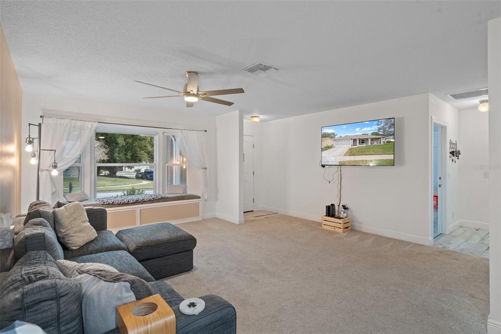 8130 Merrimac Drive Port Richey, FL 34668 - Photo 9 of 53 a living room with furniture ceiling fan and a rug