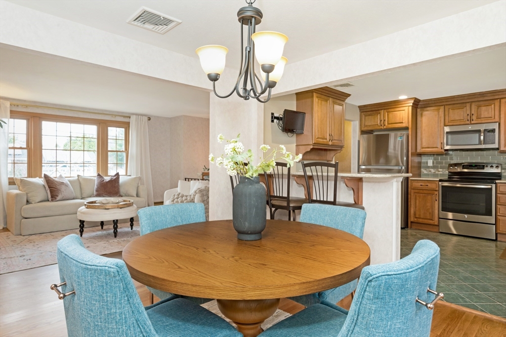 74 Ryder Road Weymouth, MA 02190 - Photo 9 of 33 a dining room with wooden floor a chandelier a wooden table and chairs