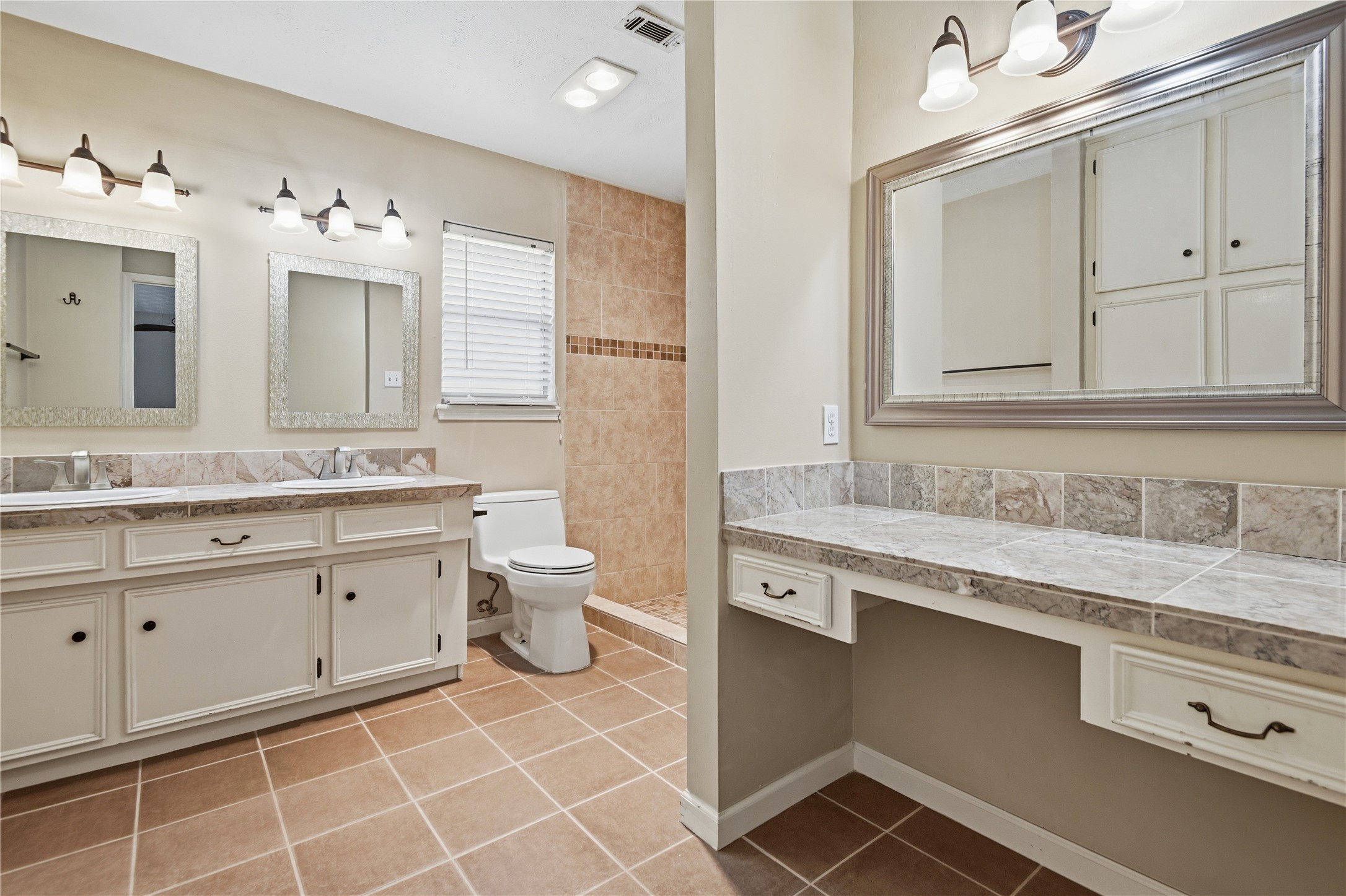 1007 Manatee Lane Houston, TX 77090 - Photo 21 of 25 a spacious bathroom with a granite countertop sink mirror and toilet