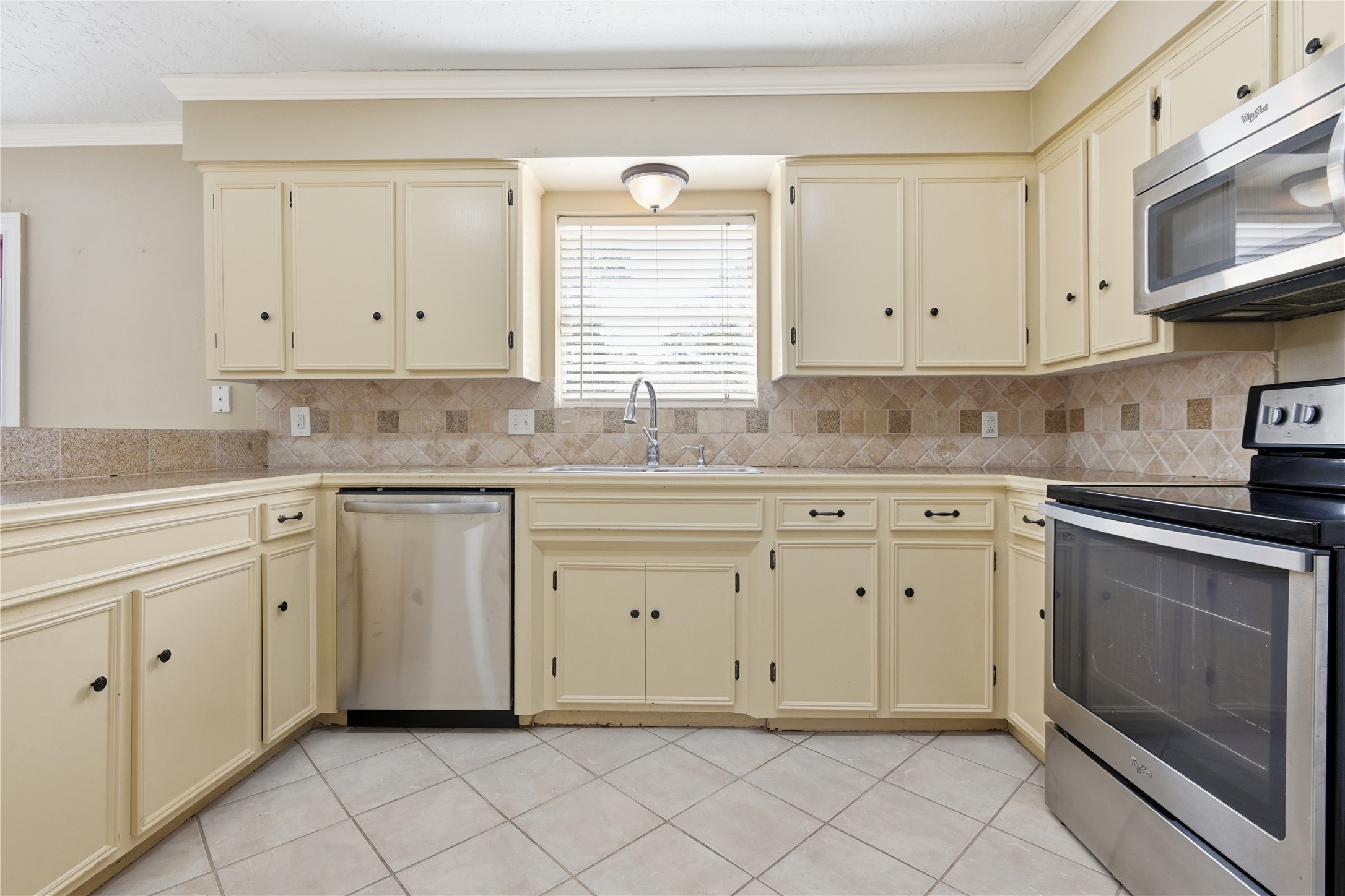 1007 Manatee Lane Houston, TX 77090 - Photo 9 of 25 a kitchen with granite countertop white cabinets stainless steel appliances white sink and dishwasher
