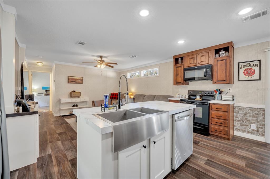 1326 Southwest 69th Road Bushnell, FL 33513 - Photo 13 of 30 a open kitchen with stainless steel appliances granite countertop a sink a stove and a refrigerator