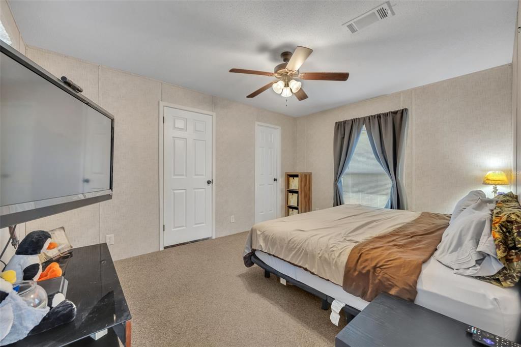 1326 Southwest 69th Road Bushnell, FL 33513 - Photo 15 of 30 a bedroom with a bed and a chandelier