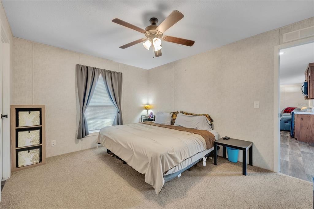 1326 Southwest 69th Road Bushnell, FL 33513 - Photo 16 of 30 a bedroom with a bed and a chandelier