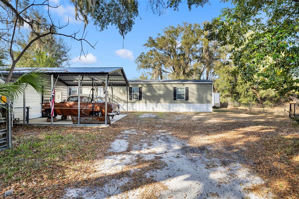 1326 Southwest 69th Road Bushnell, FL 33513 - Photo 26 of 30 a view of a house with backyard porch and sitting area