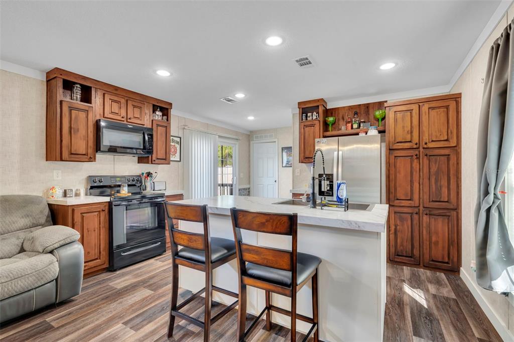 1326 Southwest 69th Road Bushnell, FL 33513 - Photo 8 of 30 a kitchen with stainless steel appliances granite countertop a refrigerator and a stove top oven