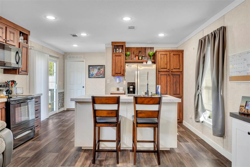 1326 Southwest 69th Road Bushnell, FL 33513 - Photo 9 of 30 a dining room with stainless steel appliances a dining table chairs refrigerator and sink