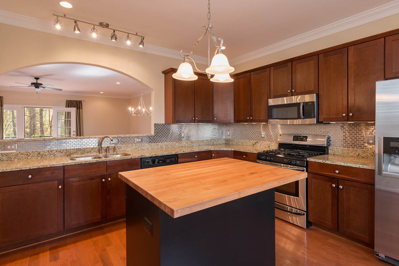 335 Quarry Road, Unit 20 Charlottesville, VA 22902 - Photo 7 of 29 Beautiful custom kitchen features Venetian gold granite countertops, Cherry cabinetry, stainless steel appliances, gas cooking, hardwood flooring, abundant recessed and track lighting (with dimmers). Island 36 x 48 with abundant storage and pull outs.