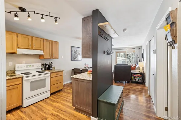 a kitchen with stainless steel appliances granite countertop a refrigerator a stove and a wooden floors