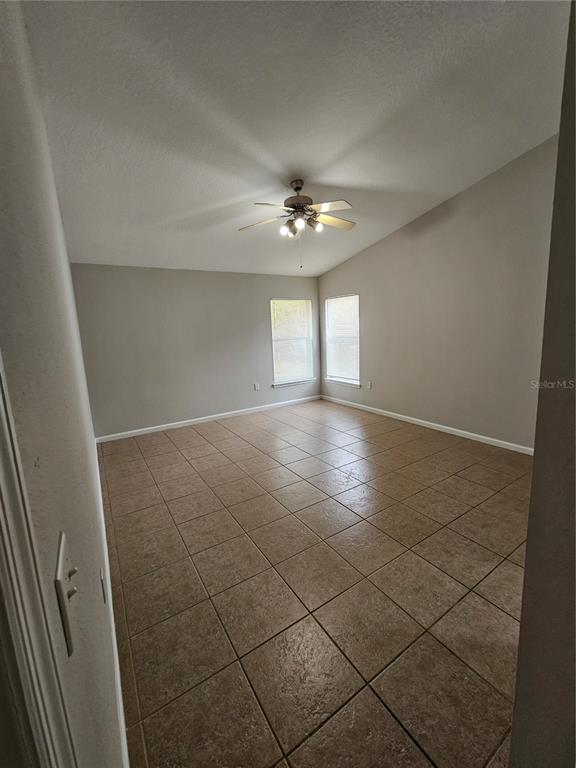 4182 Bedford Road Sanford, FL 32773 - Photo 12 of 18 en empty room with windows and fan