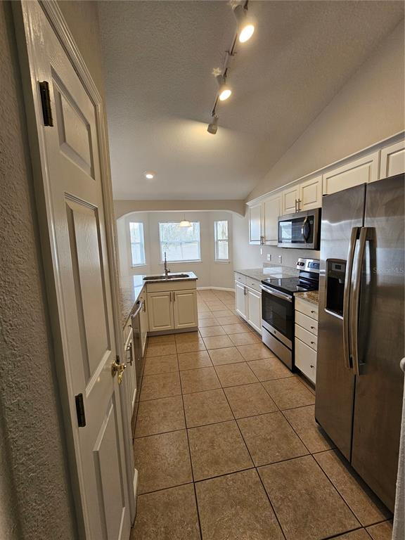 4182 Bedford Road Sanford, FL 32773 - Photo 6 of 18 a kitchen with stainless steel appliances granite countertop a refrigerator and a stove top oven