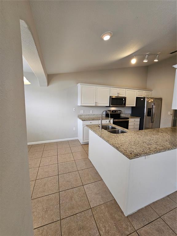 4182 Bedford Road Sanford, FL 32773 - Photo 7 of 18 a large kitchen with granite countertop a stove a sink and a microwave