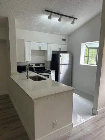 a kitchen with stainless steel appliances a sink a stove a refrigerator and cabinets