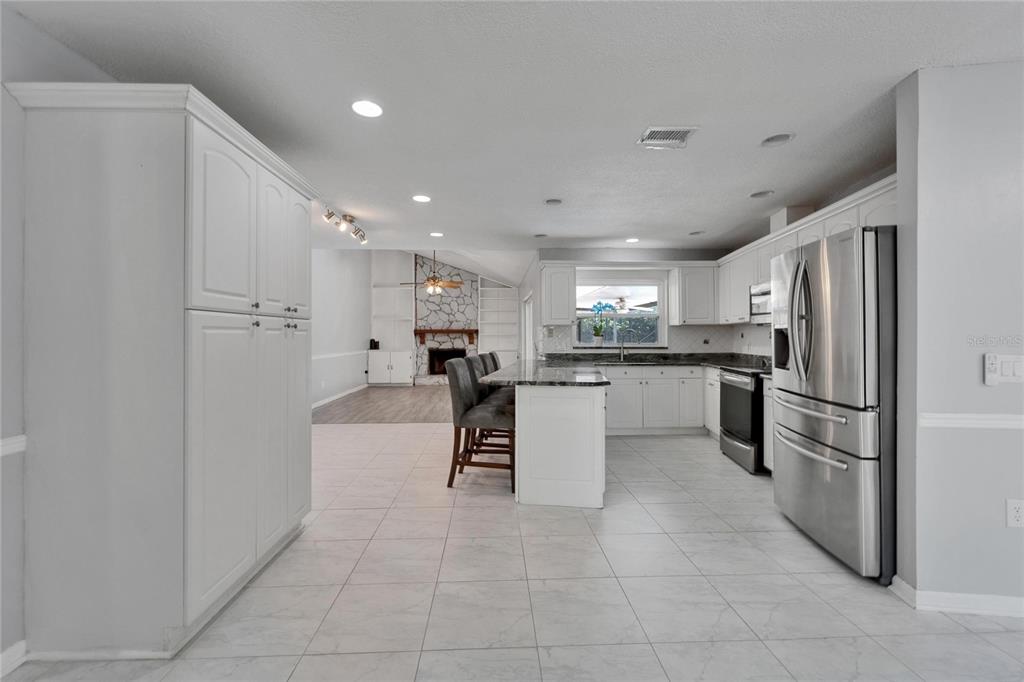 9403 Bellhaven Street Temple Terrace, FL 33637 - Photo 12 of 59 a kitchen with refrigerator and cabinets