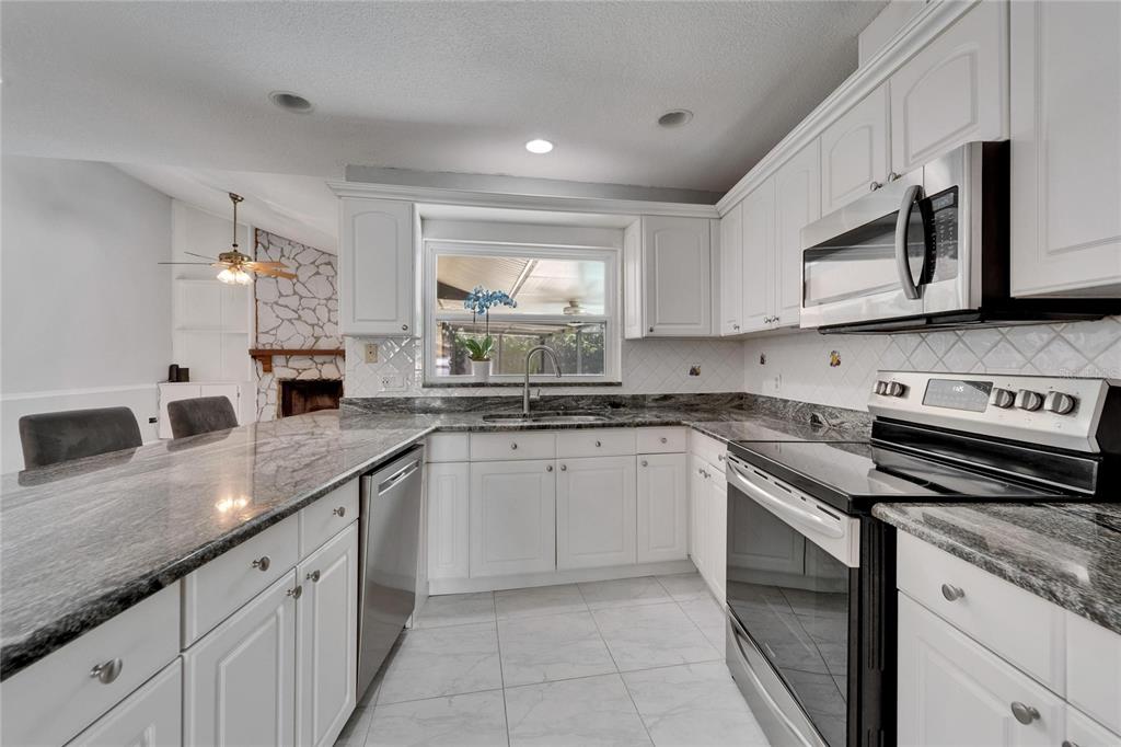 9403 Bellhaven Street Temple Terrace, FL 33637 - Photo 15 of 59 a kitchen with stainless steel appliances granite countertop a sink and a stove
