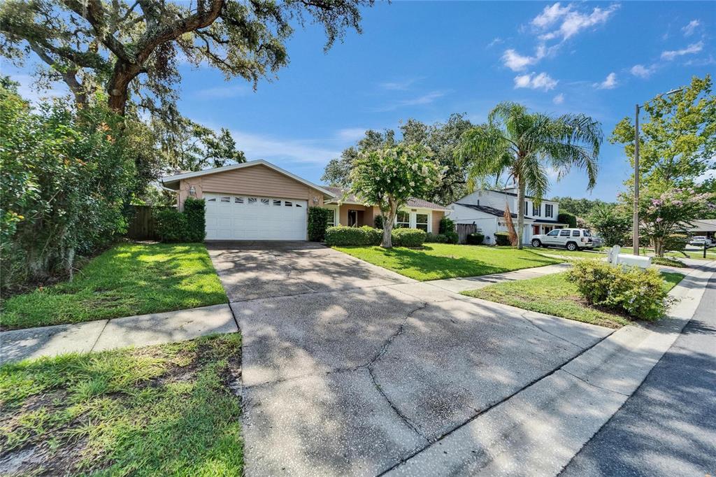9403 Bellhaven Street Temple Terrace, FL 33637 - Photo 2 of 59 a front view of a house with a yard and garage