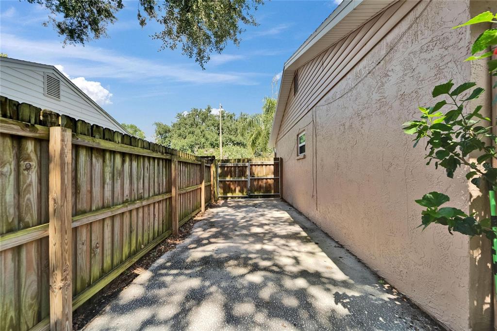 9403 Bellhaven Street Temple Terrace, FL 33637 - Photo 51 of 59 a view of a pathway of a white building with wooden fence