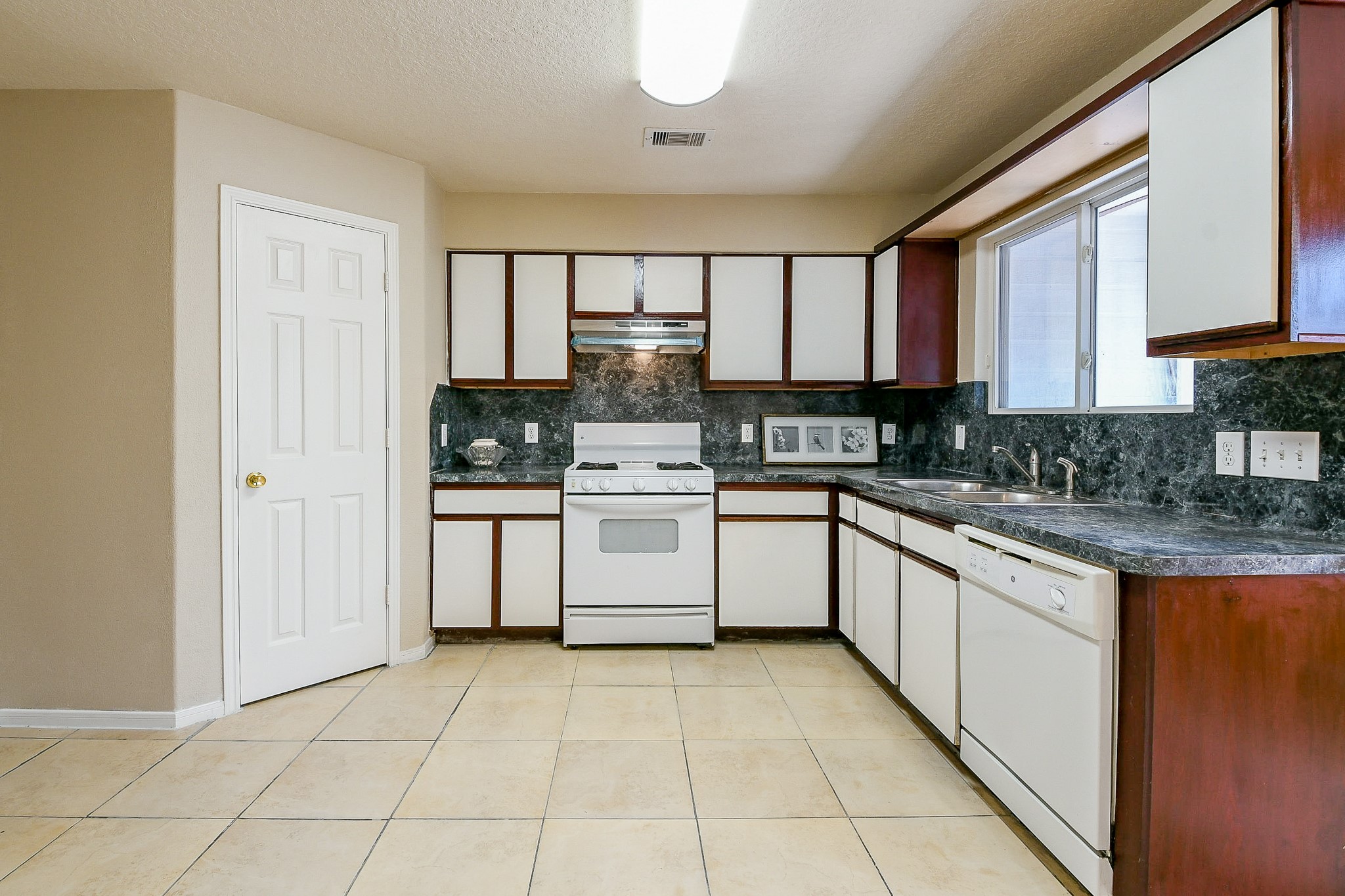 5818 Turmeric Drive Baytown, TX 77521 - Photo 20 of 50 a kitchen with a stove a sink and a refrigerator