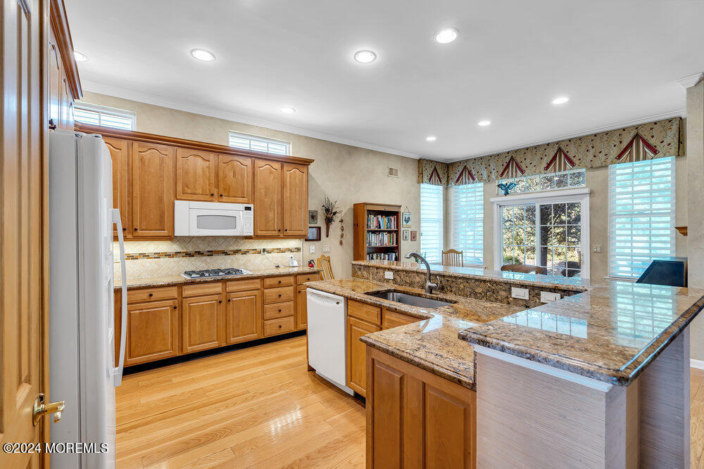 27 Exeter Drive Freehold, NJ 07728 - Photo 12 of 55 a kitchen with stainless steel appliances granite countertop stove top oven refrigerator and cabinets
