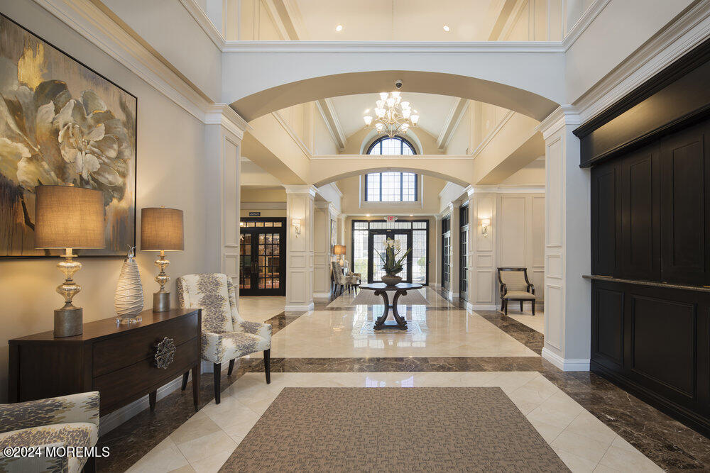 27 Exeter Drive Freehold, NJ 07728 - Photo 44 of 55 a living room with furniture a chandelier and a dining table with wooden floor
