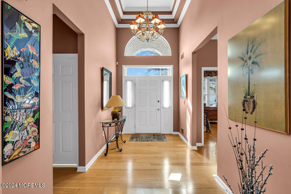 27 Exeter Drive Freehold, NJ 07728 - Photo 6 of 55 a view of a hallway with wooden floor and a dining room