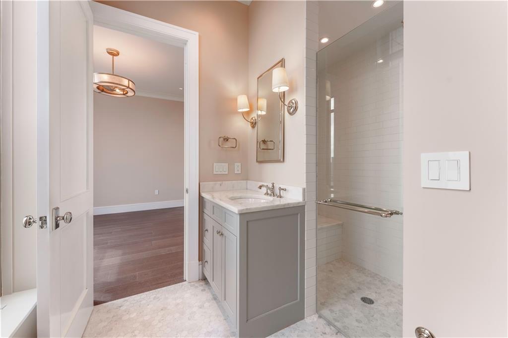 3376 Peachtree Road Northeast, Unit 35A Atlanta, GA 30326 - Photo 16 of 23 a bathroom with a shower sink and mirror