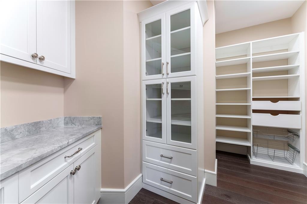 3376 Peachtree Road Northeast, Unit 35A Atlanta, GA 30326 - Photo 7 of 23 a view of an empty room with wooden floor and cabinets