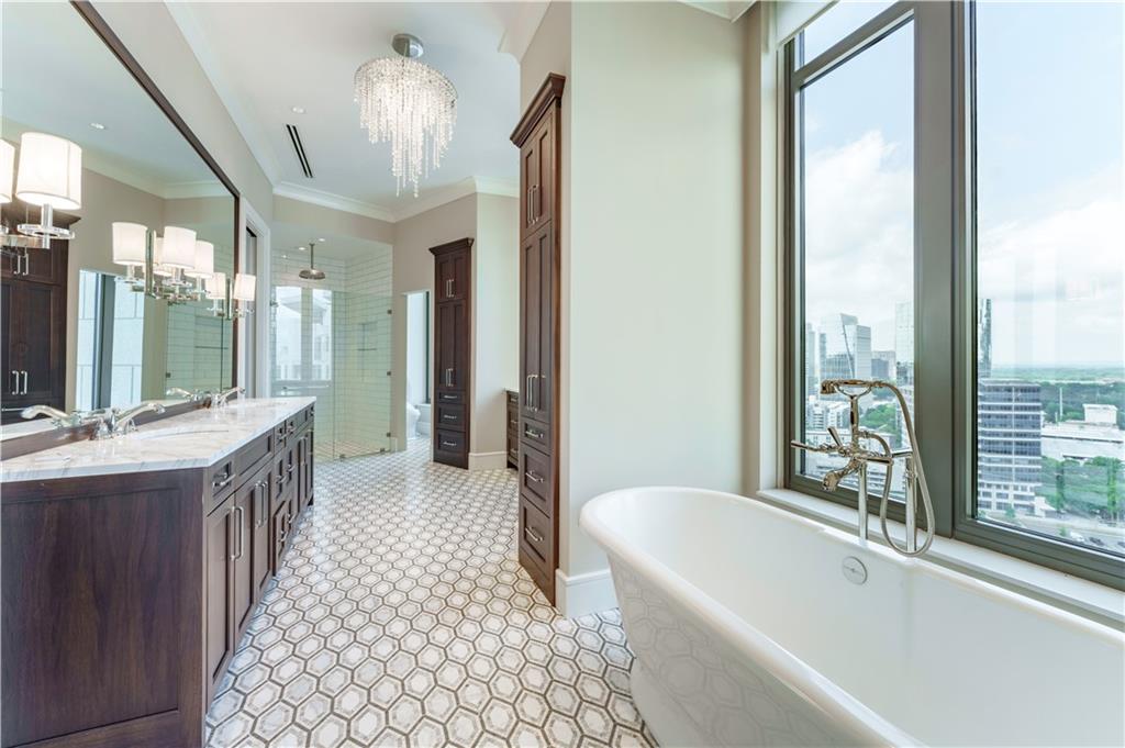 3376 Peachtree Road Northeast, Unit 35A Atlanta, GA 30326 - Photo 10 of 23 a bathroom with a bathtub a sink and a large mirror