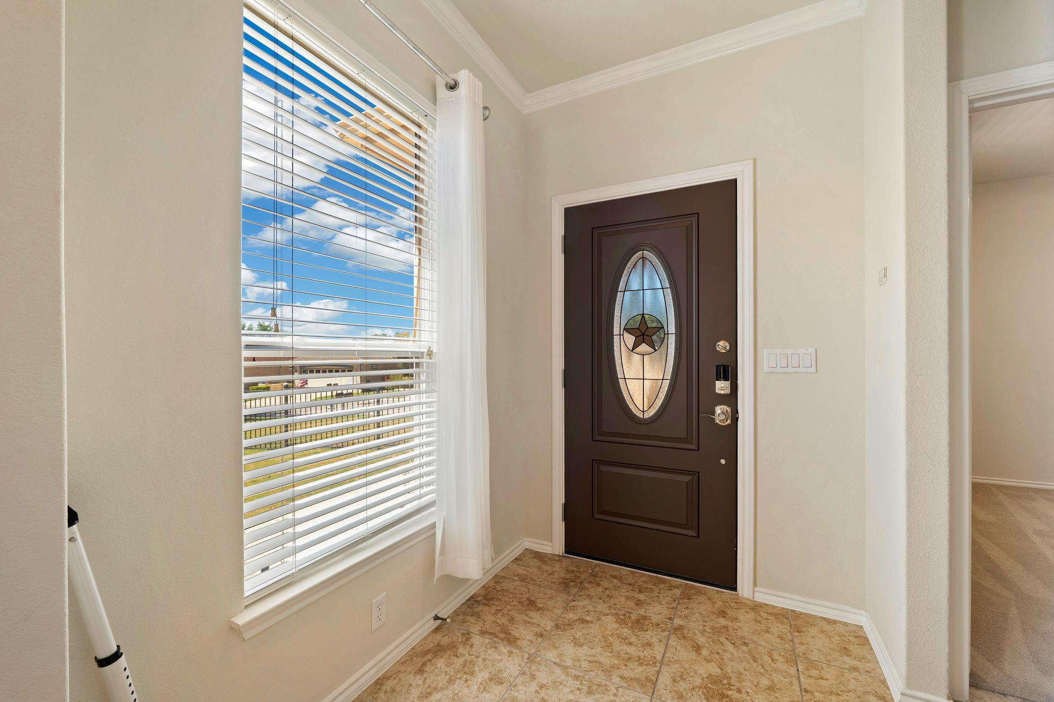 520 Mill Pond Path Georgetown, TX 78633 - Photo 10 of 38 A well-lit entry with a decorative glass door and crown molding throughout.