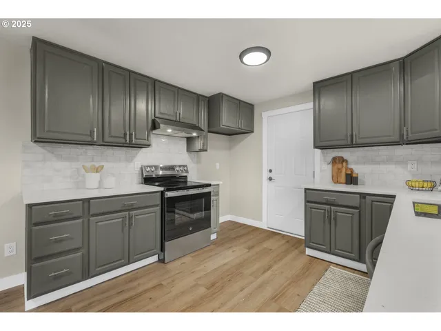 a kitchen with granite countertop wooden cabinets and a stove top oven