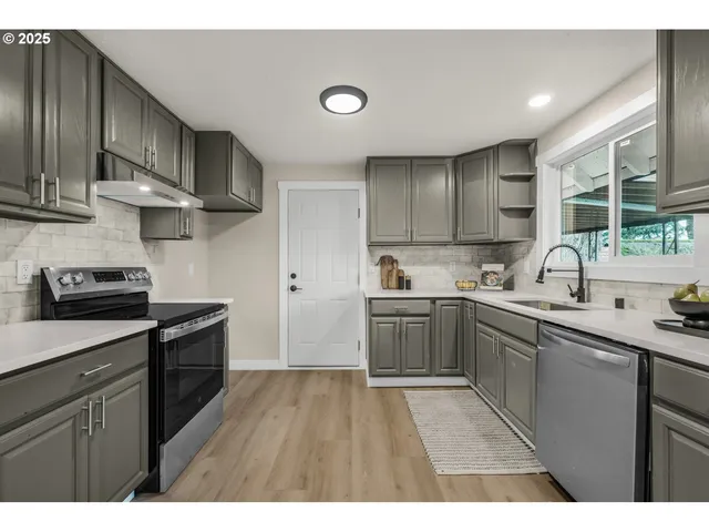 a kitchen with a sink a stove and cabinets