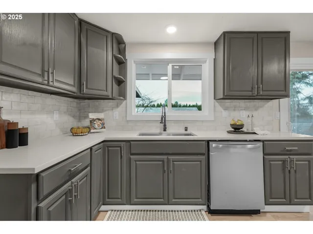 a kitchen with stainless steel appliances granite countertop a sink a stove and cabinets