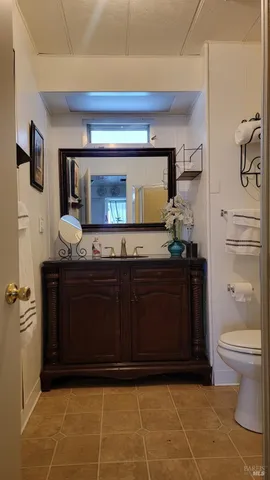 a bathroom with a granite countertop sink and a toilet