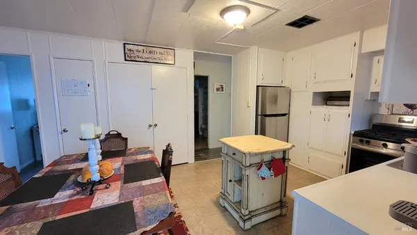 a living room with stainless steel appliances kitchen island granite countertop furniture and a refrigerator