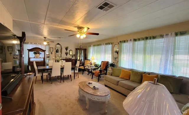 a living room with furniture kitchen view and a chandelier
