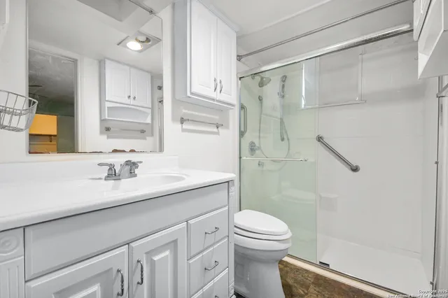 a bathroom with a granite countertop sink toilet and shower