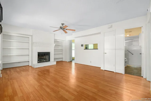 a view of an empty room with a fireplace and a window