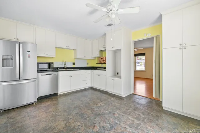 a kitchen with stainless steel appliances a refrigerator sink and cabinets