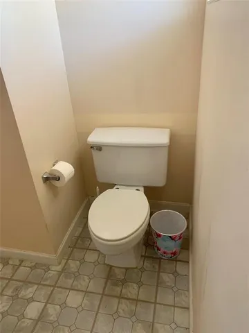 a white toilet sitting next to a white wall