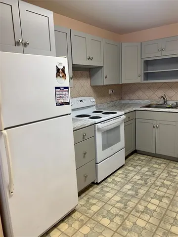 a kitchen with cabinets and white appliances