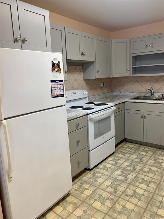 1710 Northeast 191st Street, Unit 4123 Miami, FL 33179 - Photo 3 of 17 a kitchen with cabinets and white appliances