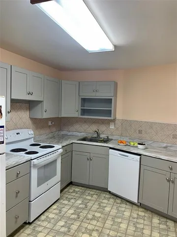 a kitchen with granite countertop white cabinets and white appliances