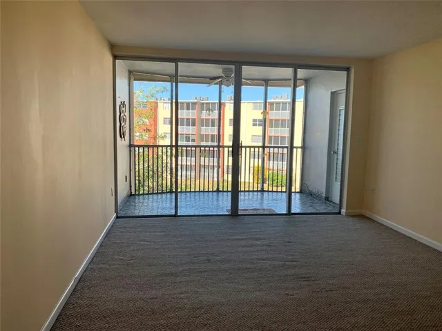 a view of a big room with wooden floor and windows