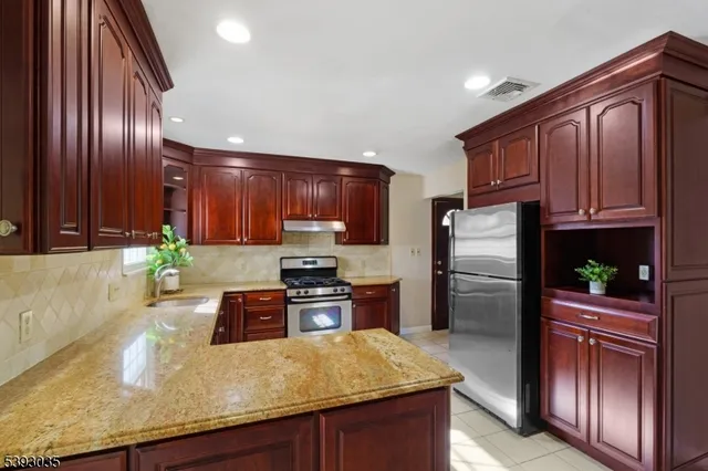a kitchen with granite countertop stainless steel appliances and wooden cabinets