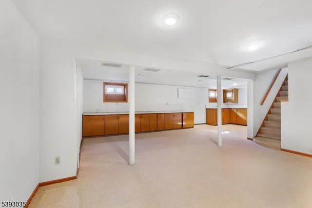 an empty room with stairs and a view of bedroom