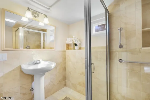 a bathroom with a sink mirror and a shower