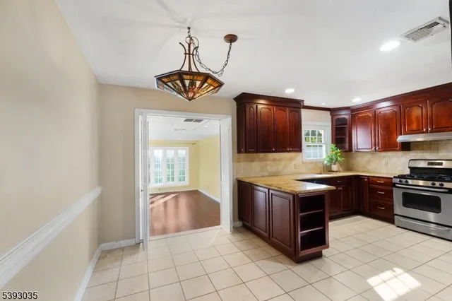 a kitchen with stainless steel appliances granite countertop a stove a refrigerator and a sink