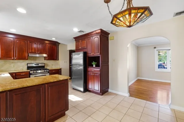 a kitchen with stainless steel appliances granite countertop a refrigerator and a stove top oven