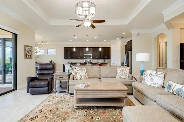 a view of a kitchen with granite countertop kitchen island stainless steel appliances a sink stove and living room view