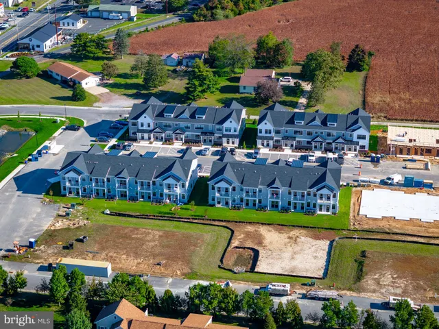 an aerial view of residential houses with outdoor space and swimming pool